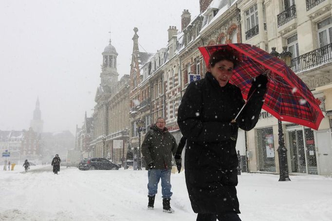 Pedestrians walk on a snow-covered street in Cambrai, northern France, March 12, 2013 as winter weather with snow and freezing temperatures returns to northern France. REUTERS/Pascal Rossignol (FRANCE - Tags: ENVIRONMENT) Published: Bře. 12, 2013, 9:46 dop.