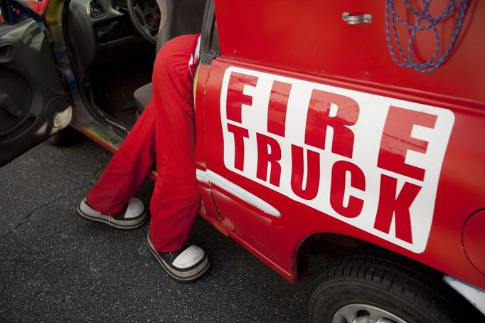 Clown Kellan Bermudez of Ecuador checks over a clown fire truck after a Cole Brothers Circus of the Stars show in Myrtle Beach, South Carolina, March 31, 2013. Bermudez also serves as the circus star The Human Cannonball. Traveling circuses such as the Cole Brothers Circus of the Stars, complete with its big top tent, set up their tent city in smaller markets all along the East Coast of the United States as they aim to bring the circus to rural areas. The Cole Brothers Circus, now in its 129th edition, travels to 100 cities in 20-25 states and stages 250 shows a year. Picture taken March 31, 2013. REUTERS/Randall Hill (UNITED STATES - Tags: SOCIETY ENTERTAINMENT) Published: Dub. 1, 2013, 7 odp.