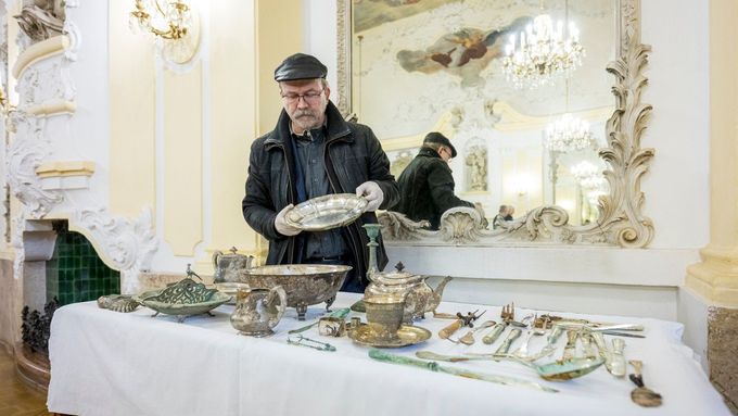 Poklad barona Liebiega, jehož součástí je stříbrný kuchyňský servis, dlouhé střelné zbraně, lovecké tesáky a několik lahví vína. Na snímku archeolog Petr Brestovanský.