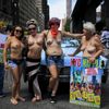 Women pose for a picture before starting a topless march in New York
