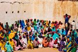 Uprchlice z Dárfúru čekají před budovou, kde se rozdávají potraviny.