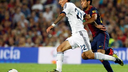Fotbalista Realu Madrid Ángel di María uniká před Sergiem Busquetsem v utkání Primera División 2012/13 proti Barceloně.
