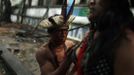 A Brazilian Indian paints on the body of an Indian woman before a ceremony at the Brazilian Indian Museum in Rio de Janeiro, March 18, 2013. A native Indian community of around 30 individuals who have been living in the abandoned Indian Museum since 2006, were summoned to leave the museum in 72 hours by court officials since last Friday, local media reported. The group is fighting against the destruction of the museum, which is next to the Maracana Stadium, to make way for a planned 10,000-car parking lot in preparation for the 2014 Brazil World Cup. REUTERS/Pilar Olivares (BRAZIL - Tags: SOCIETY CIVIL UNREST) Published: Bře. 18, 2013, 10:38 odp.