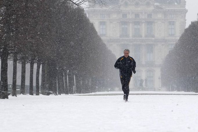 A jogger runs in the snow-covered Tuileries gardens in Paris March 12, 2013 as winter weather with snow and freezing temperatures returns to northern France. REUTERS/Gonzalo Fuentes (FRANCE - Tags: ENVIRONMENT) Published: Bře. 12, 2013, 2:30 odp.