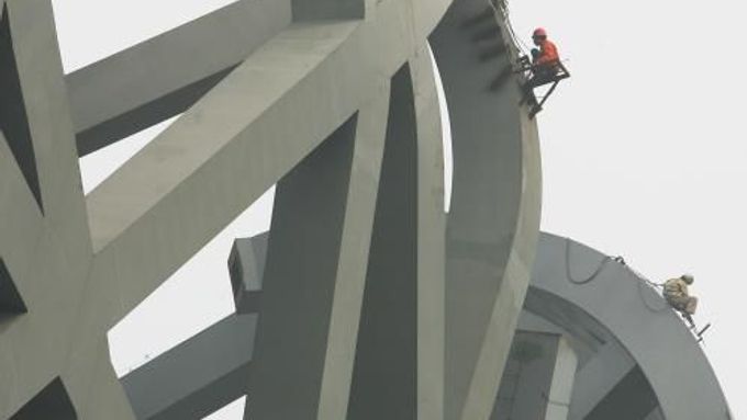 Čínští dělníci pracují v Pekingu na Národním stadionu, kde budou zahájeny i ukončeny olympijské hry v roce 2008.