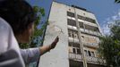 Vrchní sestra ukazuje stopy po ruském ostřelování na zdi nemocnice v Chersonu.