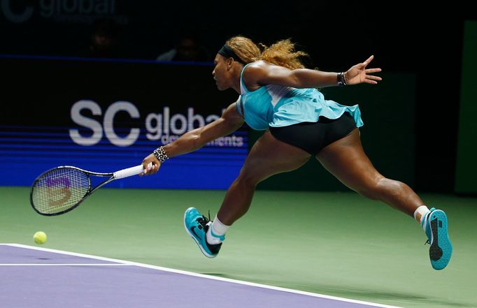 Serena Williams of the U.S. hits a return to Caroline Wozniacki of Denmark during their WTA Finals singles semi-final tennis match at the Singapore Indoor Stadium October