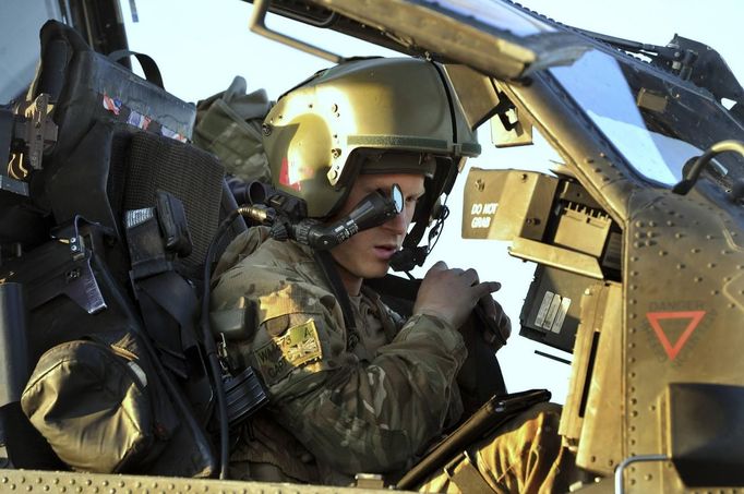 Britain's Prince Harry wears his monocle gun sight as he sits in his Apache helicopter in Camp Bastion, southern Afghanistan in this photograph taken November 2, 2012, and released January 21, 2013. The Prince, who is serving as a pilot/gunner with 662 Squadron Army Air Corps, is on a posting to Afghanistan that runs from September 2012 to January 2013. Photograph taken November 2, 2012. REUTERS/John Stillwell/Pool (AFGHANISTAN - Tags: MILITARY POLITICS SOCIETY ROYALS CONFLICT) Published: Led. 21, 2013, 9:05 odp.