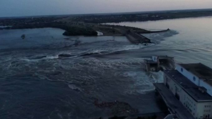 Poškozenou přehradou Nová Kachovka na Ukrajině protéká voda.