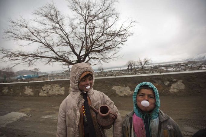 Afghánští chlapci se předvádí před fotografem agentury Reuters v Kábulu.