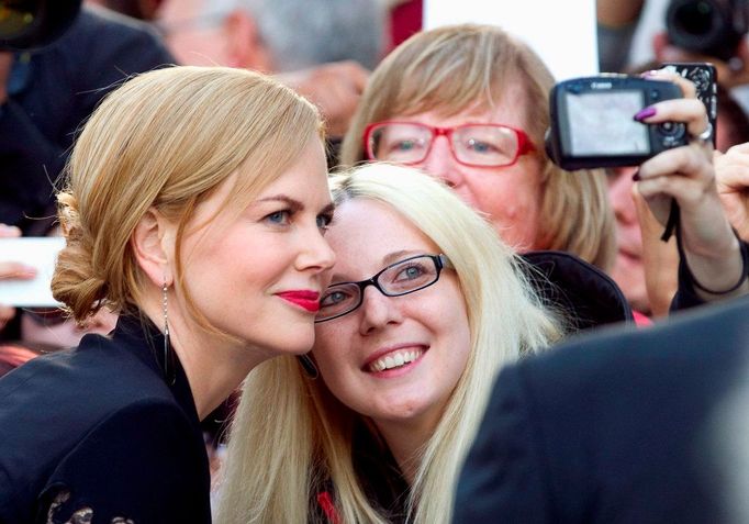 Nicole Kidman (L) poses for a photo with a fan as she arrives for the premiere of the film "The Railway Man