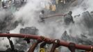 People help rescue workers extinguish a fire after a plane crashed into a neighbourhood in Ishaga district, an outskirt of Nigeria's commercial capital Lagos June 3, 2012. There were no survivors among the 147 people on board a domestic passenger aircraft that crashed in the Nigerian city of Lagos on Sunday, an official of the National Emergency Management Agency (NEMA), told Reuters. REUTERS/Akintunde Akinleye (NIGERIA - Tags: DISASTER TRANSPORT) Published: Čer. 3, 2012, 9:01 odp.