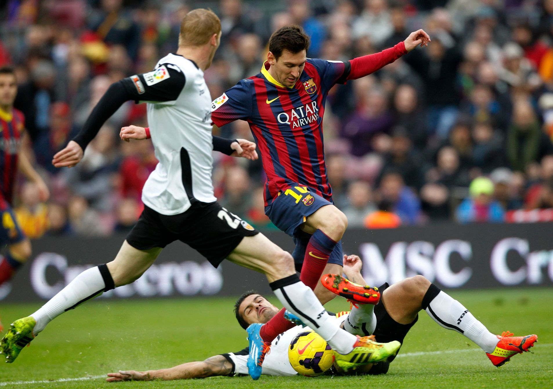 Barcelona's Lionel Messi vies the ball against Valencia's captain Ricardo Costa and Jeremy Methieu during their Spanish first division soccer match at Camp Nou stadium in Barcelona