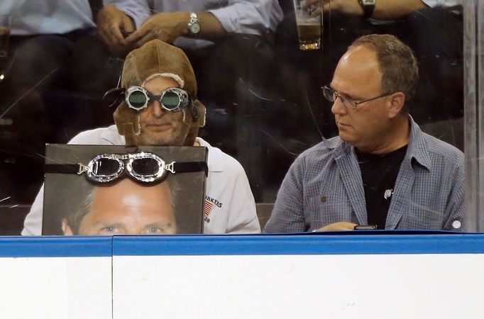 A fan watching the New York Rangers play the Boston Bruins from a front row seat gets a reaction from his neighbor during the second period of Game 3 of their NHL Eastern