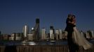 A couple, posing for their pre-wedding photographs, are back-dropped by the One World Trade Center and Manhattan skyline as seen from New Jersey April 29, 2012. A steel column will be hoisted atop the One World Trade Center on Monday, making it New York's tallest building, local media reported. The first column of the 100th floor of One World Trade Center will bring the tower to a height of 1,271 feet (387 meters), making it 21 feet (6 meters) higher than the Empire State Building, media said. REUTERS/Eduardo Munoz (UNITED STATES - Tags: CITYSPACE SOCIETY) Published: Dub. 30, 2012, 5:06 dop.