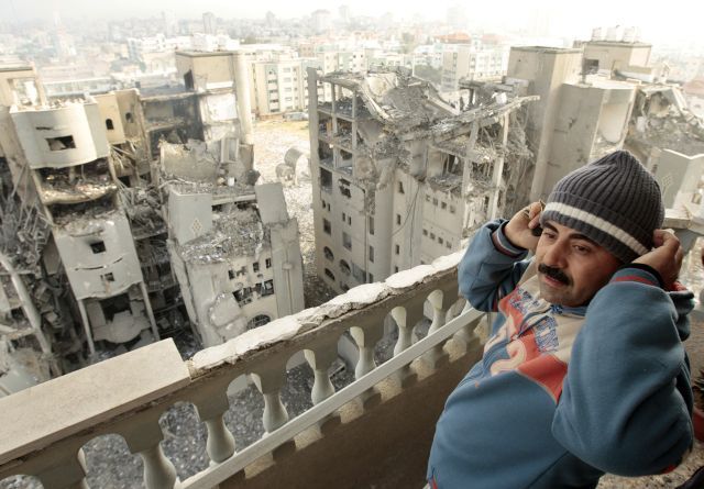 Palestinec pozoruje budovy Hamasu zasažené izraelským náletem