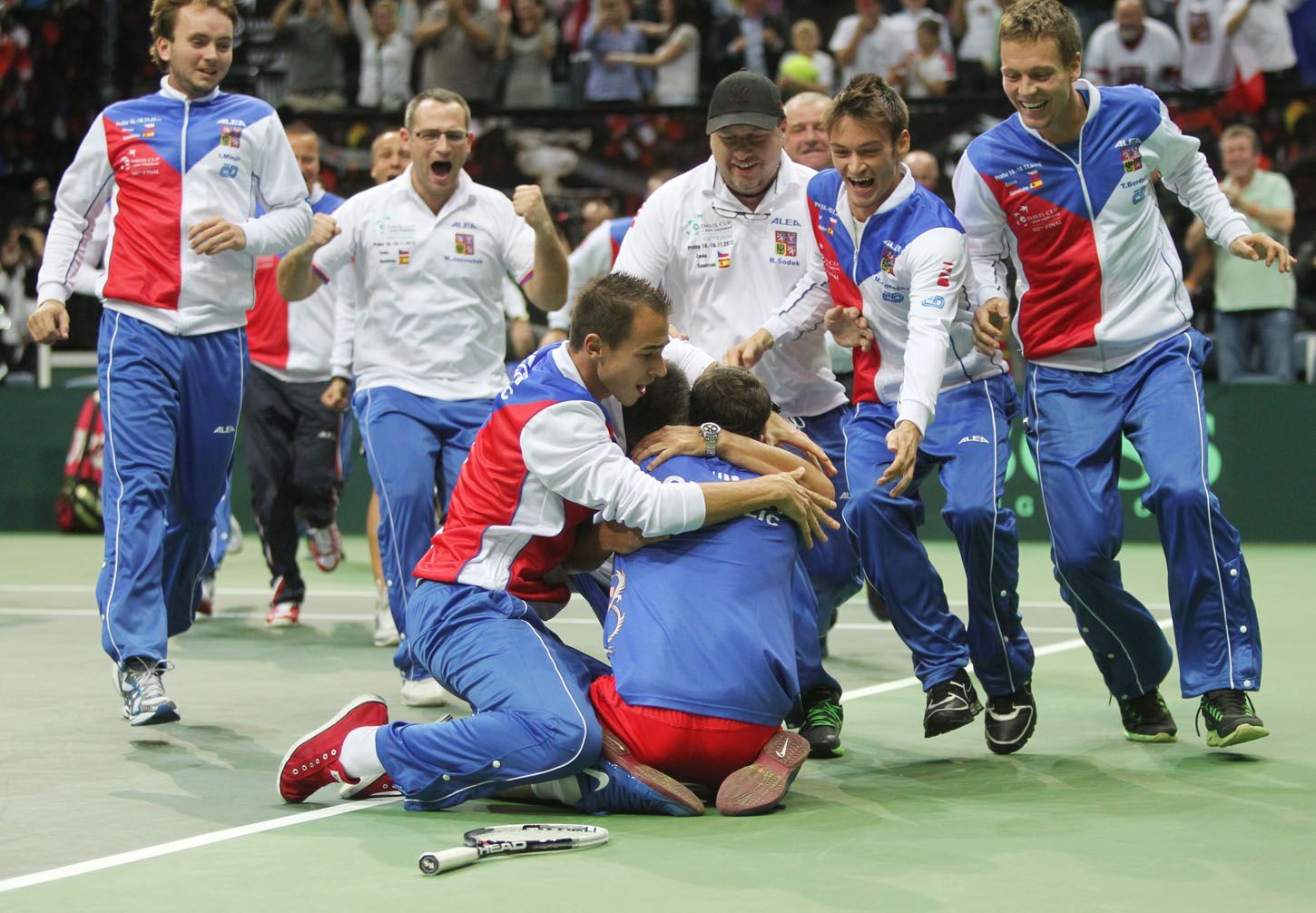 Čeští tenisté se radují z vítězství ve finále Davis Cupu 2012 proti Španělsku.