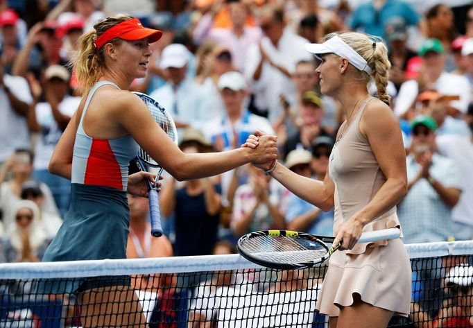 Caroline Wozniacki (R) of Denmark shakes hands with Maria Sharpova of Russia after defeating her at the 2014 U.S. Open tennis tournament in New York