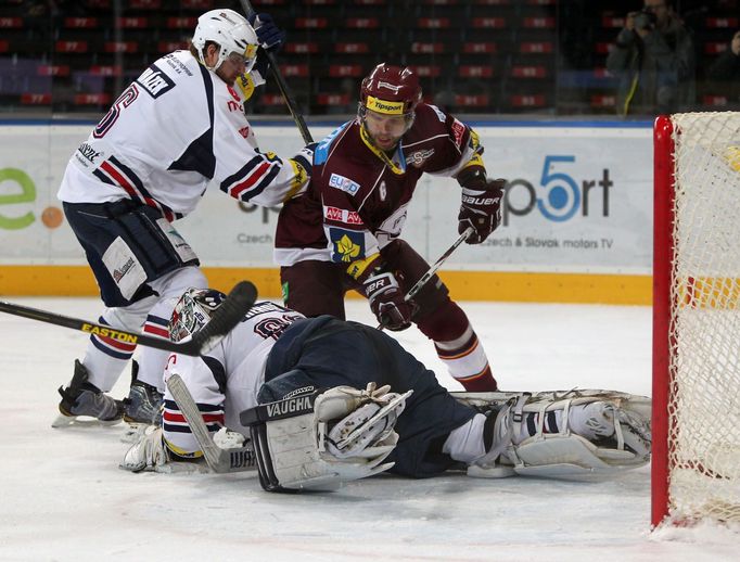 Hokejisté Chomutova Jaroslav Mrázek a brankář Milan Řehoř brání Michala Broše v utkání 16. kola Tipsport extraligy 2012/13 proti Spartě Praha.